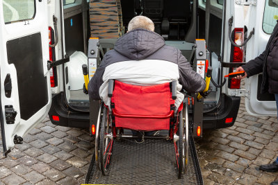 senior man on wheelchair rides in van using wheelchair ramps